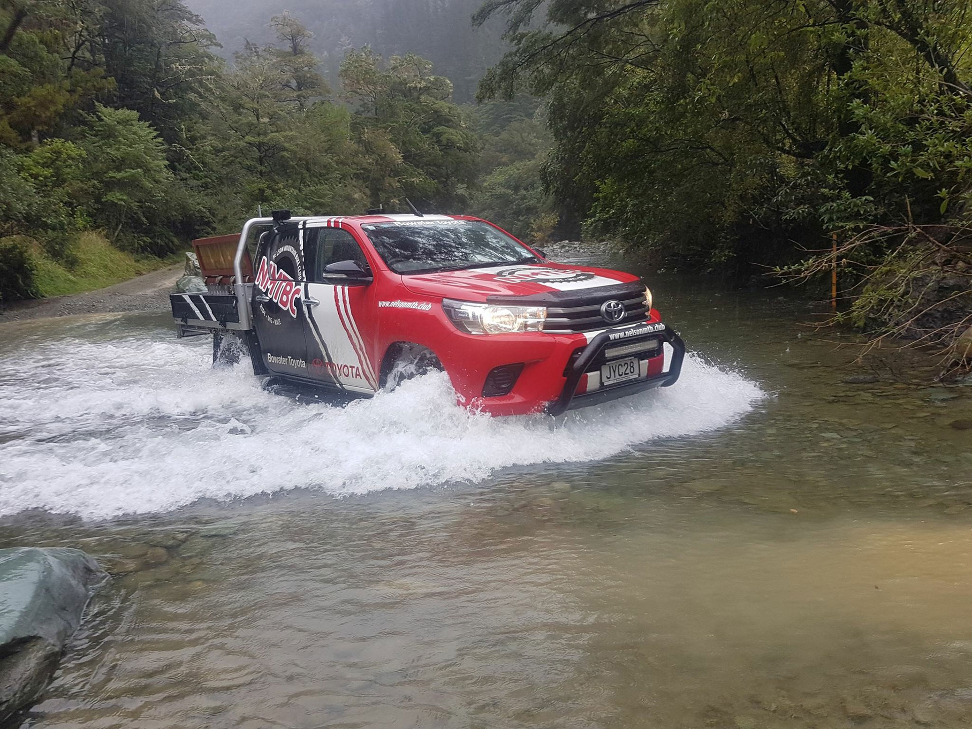 Toyota Hilux wading through a bush river